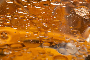 Close up view, golden yellow bubble cooking oil on water. abstract oil texture and pattern background. omega fish oil concept