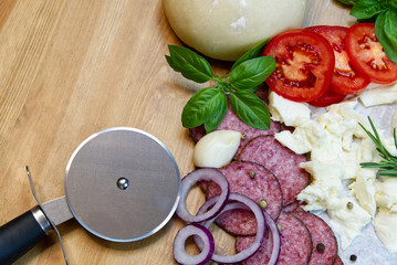 Dough basis and ingredients for pizza, on the wood table