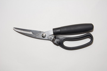 Closed Scissors with black plactics handles special for cutting of chicken and other bird On White background.