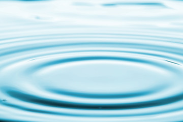 Closeup Water drop falling on the surface of the water and beautiful circular wave ripple, fresh natural mineral water drink water concept