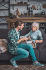 Young man in jeans measurung blood pressure