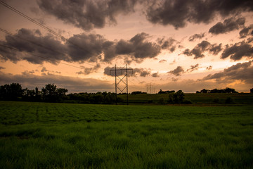 Obraz premium stormy sunset over green field