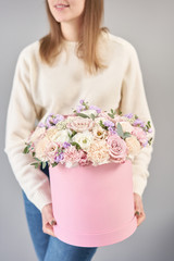 European floral shop. Floral bunch in round box. Bouquet of beautiful Mixed flowers in woman hand. Excellent garden flowers in the arrangement , the work of a professional florist.