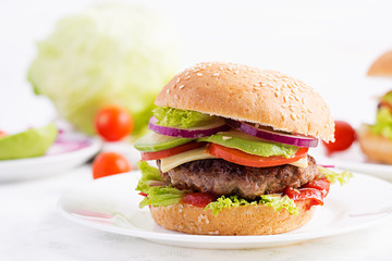 Big sandwich - hamburger burger with beef, avocado, tomato and red onions on light background. American cuisine. Fast Food
