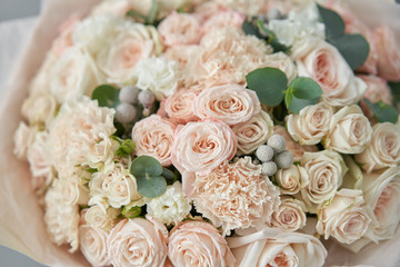 European floral shop. Beautiful bouquet of mixed flowers in womans hands. the work of the florist at a flower shop. Delivery fresh cut flower.
