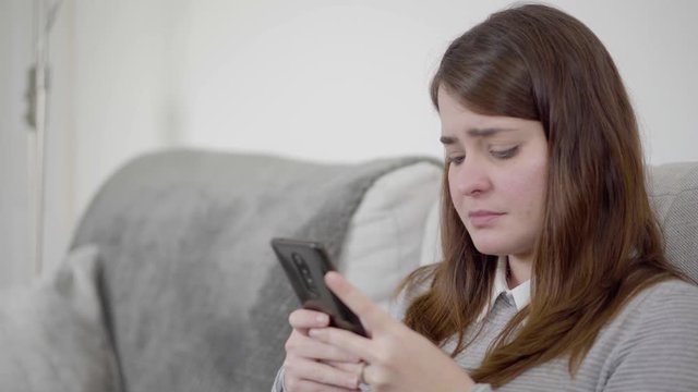 Close up of a sad woman sending message, posting in social media, or breaking up a relationship.