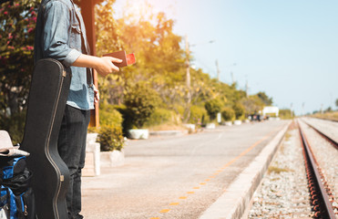 hand of traveler holding passport at railway station.