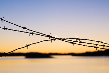 Close-up of barbed wire at sunset