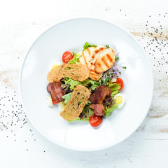 Vegetable salad with chicken fillet and bacon. Top view, free space for your text. Rustic style.