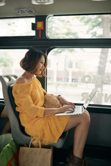 Young businesswoman on a business travel. Working on the bus using her laptop.