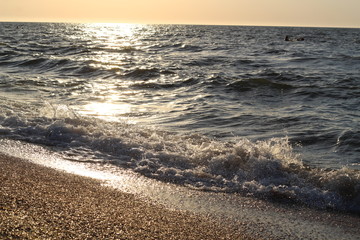 Obraz premium splashes of waves on the beach of the sea coast at sunset