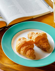 Fresh croissant is served on ceramic plate