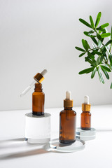 natural cosmetic skincare or essential oil bottles container and green leaf on white background....