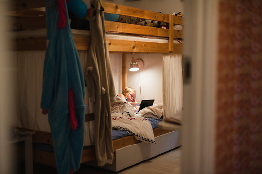 Girl using digital tablet on bed