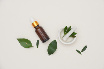 spa concept with bottles of essential oil with small leaves, .salt in bowl on white background.