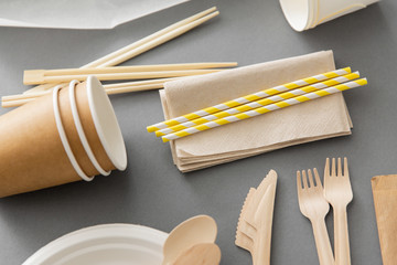 recycling, tableware and eco friendly concept - disposable dishes of paper and wood on grey...