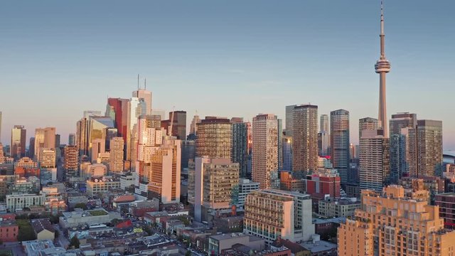 Aerial: Establishing shot of apartments & downtown Toronto city skyline at sunset. Ontario, Canada.