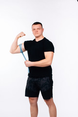 A man measures his waist. Fitness trainer. White background.