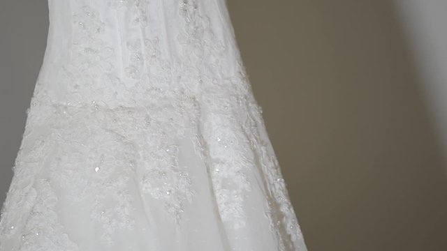 Captured details of the bride's dress hanging on the hanger, starting from the top to the bottom in the syrup, gorgeous, wonderful dress, will be a perfect wedding. Tilt capture.