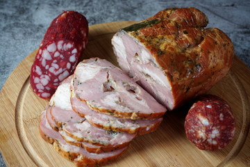 Smoked meat and salami on a cutting Board on a dark background