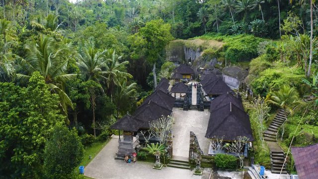 Fly over cinematic capture of Gunung Kawi Temple at Bali, Indonesia / Ubud. Tourist attraction Hindu Temple in middle of Jungle forest and rice field filmed in 4k.