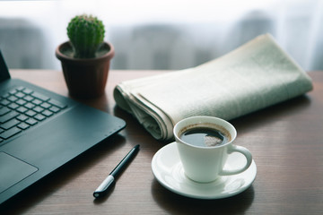 Newspaper with computer on table. Coffee break.