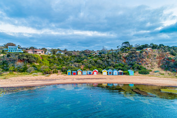 Colorful bathing boxes with reflections on ocean beach in Melbourne, Australia - 310398866