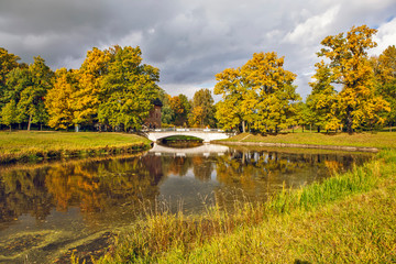 Autumn park, the Slavyanka river and the Pil-tower bridge. Pavlovsk. St. Petersburg. Russia