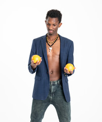 A black guy (man) in a blue jacket and jeans with oranges in his hands