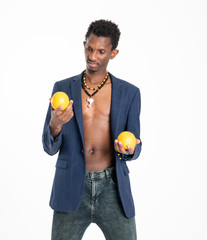 A black guy (man) in a blue jacket and jeans with oranges in his hands