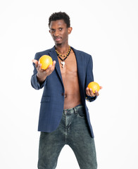 A black guy (man) in a blue jacket and jeans with oranges in his hands