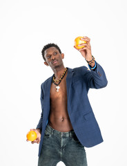 A black guy (man) in a blue jacket and jeans with oranges in his hands