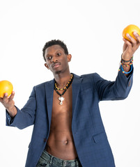 A black guy (man) in a blue jacket and jeans with oranges in his hands