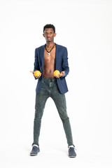 A black guy (man) in a blue jacket and jeans with oranges in his hands