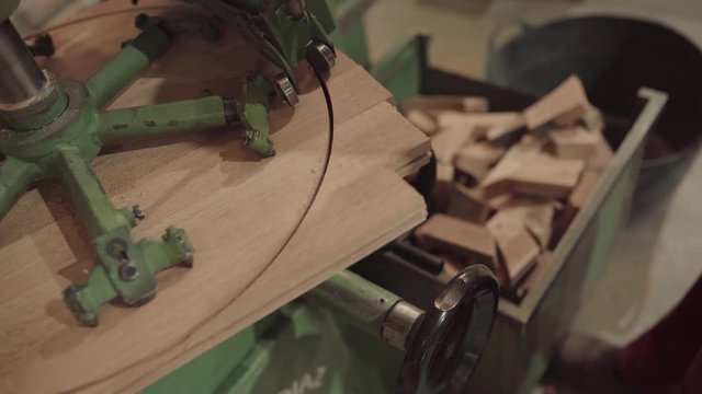 Machine cutting out circular shape of wooden barrel lid, close up