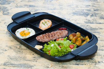 Breakfast, fried steak or cutlet, salad with tomato and green vegetables, croutons, potatoes, egg side view, light background. The concept of healthy diet, diet, menu, good nutrition.