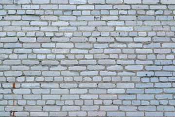 A dirty smudged red brick wall with the old paint