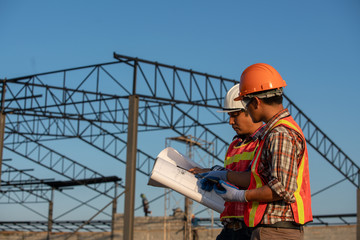 Construction work, Two engineers use blueprint analysis construction at the construction site