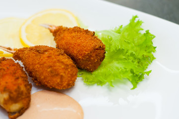 Crab claws fried in batter with lemon, lettuce and tasty sweet and sour sauce