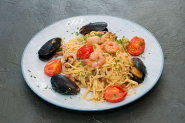 Spaghetti pasta with shrimp, mussels, tomatoes and cheese.