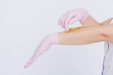Hands in rubber gloves close-up. doctor puts wax, honey. medic is preparing for depilation. Concept of medicine, health care, beauty industry, hair removal, natural material. Copy space