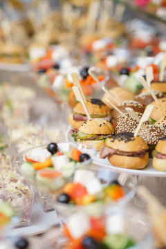 Mini burgers with meat and fish on the table prepared for the guests of the event.