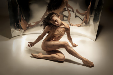 Chocolate. Young and stylish modern ballet dancer with the mirror and illusion reflections on...
