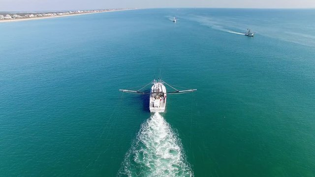A White Trawling Shrimp Boat Cruises Off into the Horizon, Birds-Eye-View Steady Shot