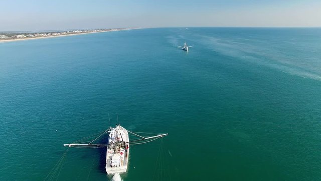 A White Trawling Shrimp Boat on the Water, Aerial Reverse Flyover