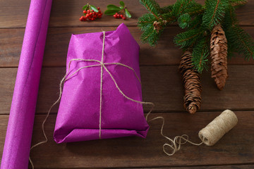 Chrismas gift wraped in craft paper over wooden table 