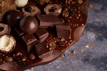 pieces of black and white chocolate, chocolates on a gray stone background Copy space
