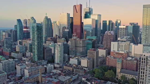 Aerial: Establishing shot of apartments & downtown Toronto city skyline at sunrise. Ontario, Canada.