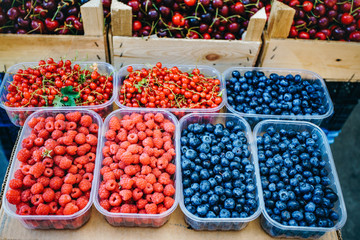 A mix of fresh berries on the market, strawberries, blueberries, raspberries, blackberries, cherries and red currants