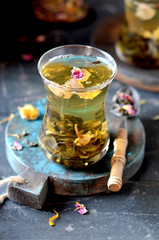 Green tea with rose petals in a glass cup